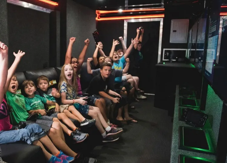 Kids playing video games inside GameTruck mobile gaming theater
