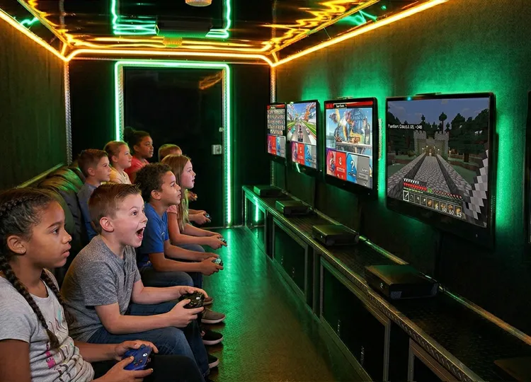 Kids playing inside the GameTruck video game trailer