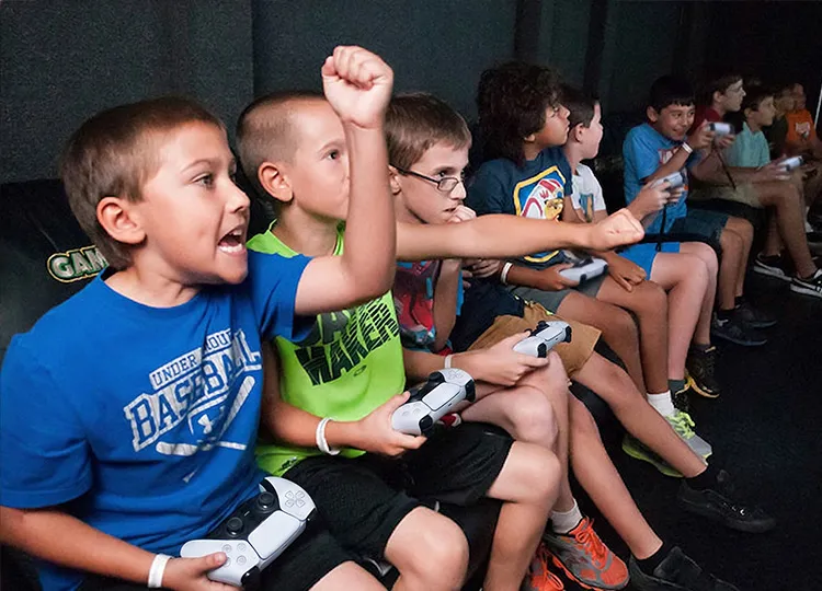 Kids playing video games inside a GameTruck mobile gaming trailer
