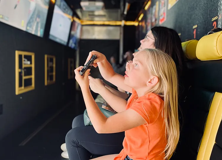 Young girl playing games in GameTruck theater at a birthday party