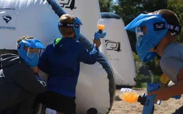 Kids firing GelTag blasters at a GameTruck outdoor GelTag birthday party